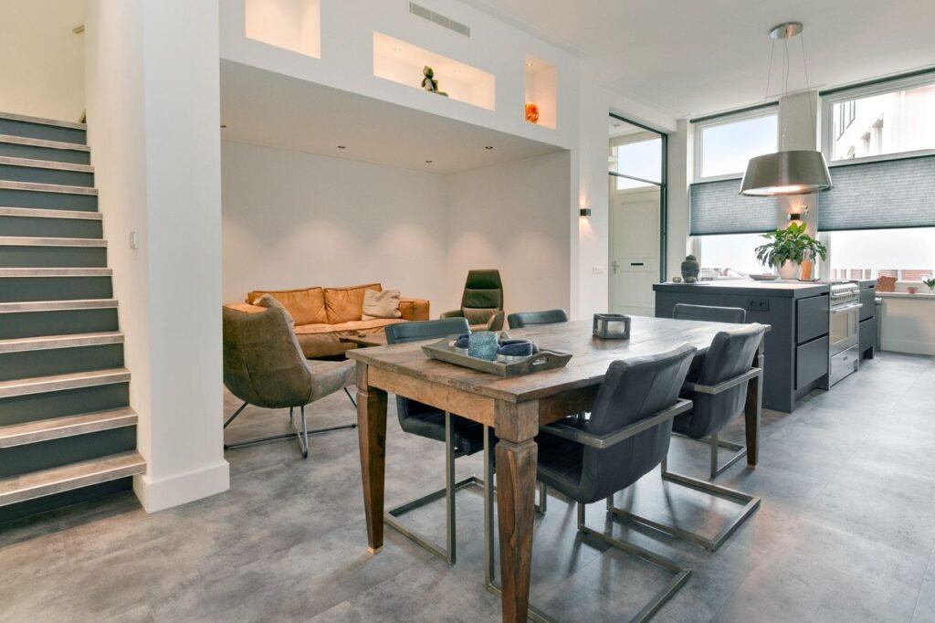 Interior de vivienda moderna con cocina abierta, comedor rústico y salón integrado